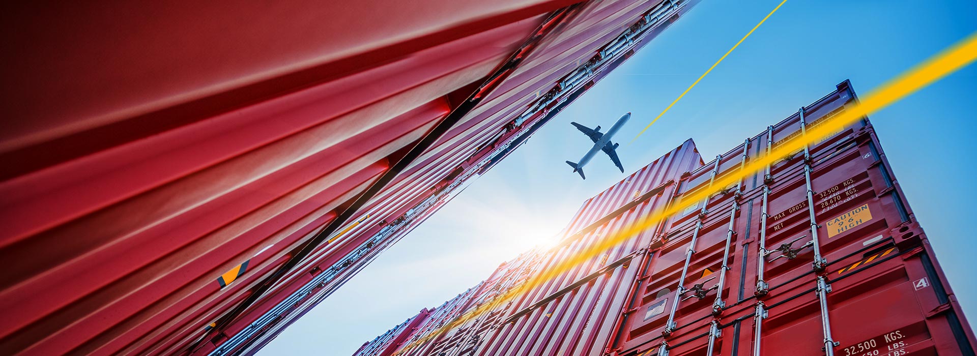 Aircraft flies over shipping container | LGI